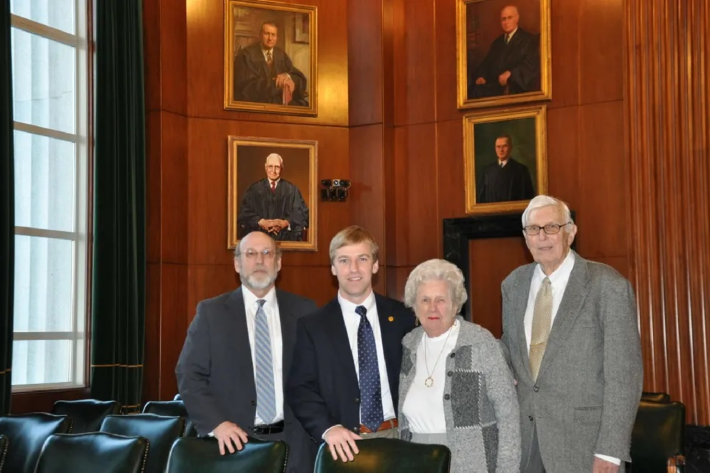 Chief Justice Emery D. Ashley is pictured in a portrait. Emery D. Ashley, Emery D. Ashley Jr., and the late Jean and Wallace Ashley Jr. are pictured standing in front of the portrait.