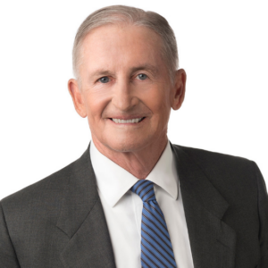 Hall, a man with grey hair, wears a white shirt, blue tie, and black jacket.