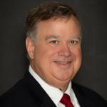 Heydt, a white man with brown hair, wears a white shirt, red tie and black jacket.