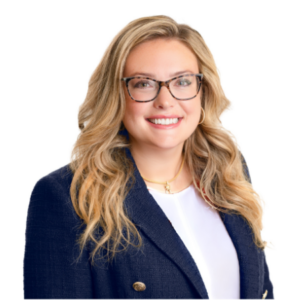 Samantha, a white woman with blond hair and brown glasses, wears a white shirt and navy blazer.